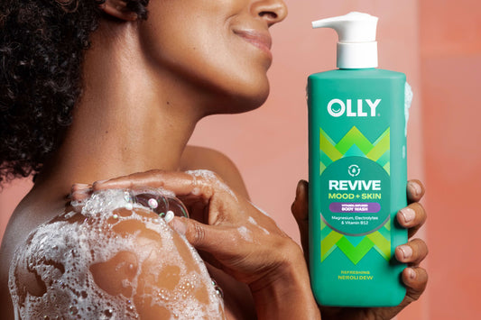 Woman holding OLLY Revive Mood + Skin Body Wash