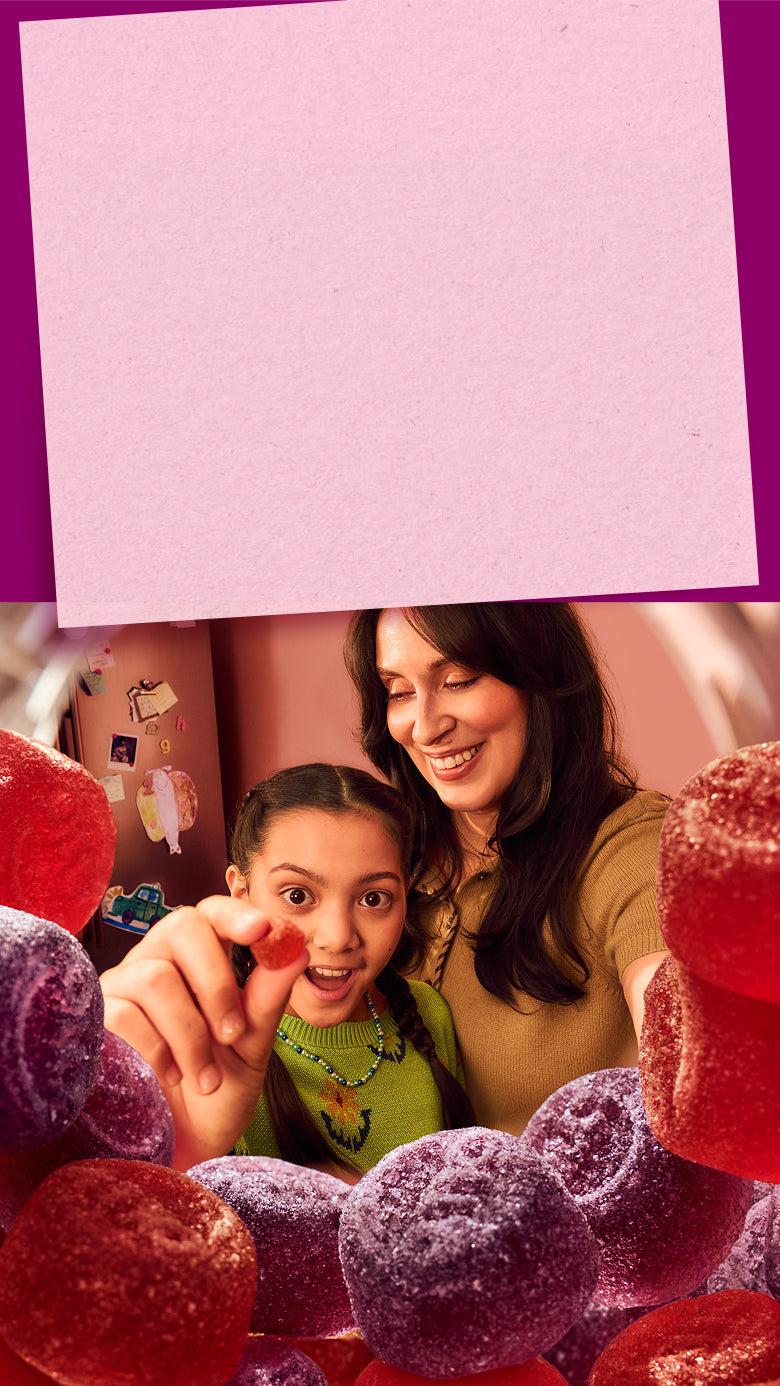 Woman with child holding an OLLY gummy
