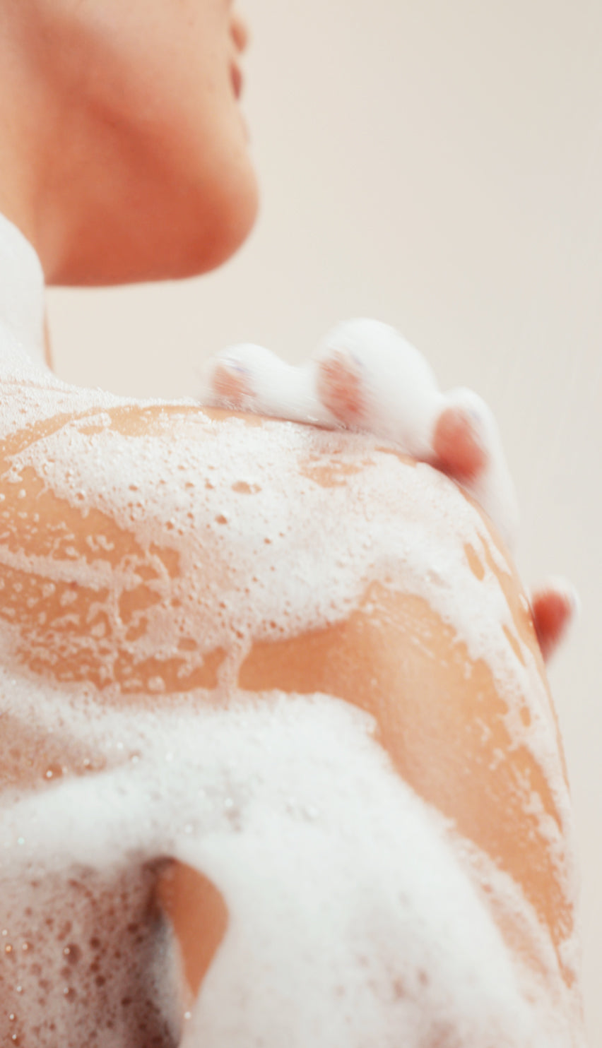 Close-up of a person's back with soap suds on a neutral background icon